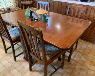 Neat oak table with four oak chairs. Wide drop down leaves 