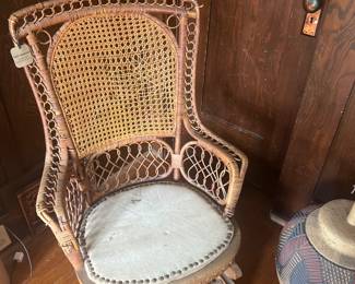 Haunted rattan rocker with little tiny wheels on the front.