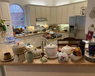 Kitchen filled with appliances, pottery, glasses, pots, pans and more