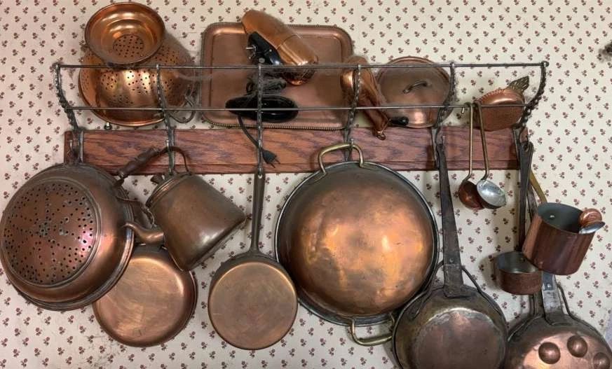 A Large Collection Of Copper Pots Luggage Rack To Hang Them On