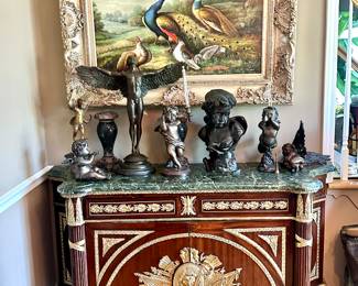 Variety of bronze statues displayed on stunning French Provincial marble top chest.