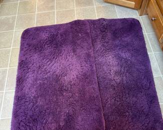 Two large purple bathroom rugs