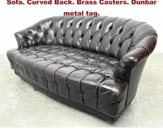Lot 813 DUNBAR Leather Tufted Chesterfield Sofa. Curved Back. Brass Casters. Dunbar metal tag. 
