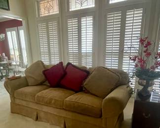 Comfortable upholstered sofa with pillows, Ethan Allen side table, florals.