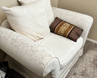 Floral upholstered white chair with pillows 