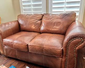 Brown leather loveseat with nailhead trim