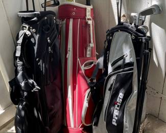 Red Nike Golf bag.  2 black golf bags. —& Golf Clubs.
