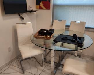 Modern glass and chrome table and white chairs