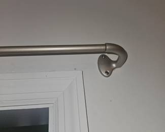 several curtain rods available. located downstairs with matching screws. some draperies available also. slides to expand. Not on the walls.