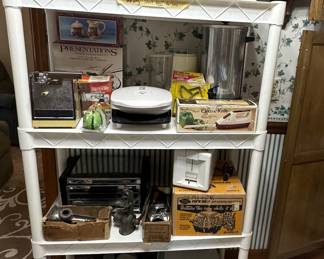 Wooden Spice Box; Ohio Art Metal Lunch Boxes; Fire King Mugs; Corning Ware Covered Casserole; Rival Gold Can Opener; Presentations Salad Bowl Set; Swing a Way Can Opener; George Foreman Grill; Electric Knife; Coffee Pot; Broil King Toaster Oven; Metal Meat Food Grinders; Toastmaster Toaster; Mirromatic Popcorn Popper; 