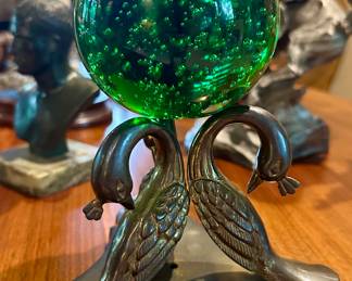 Peacocks holding brilliant green glass ball