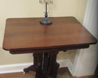 Ornate 1890's Eastlake side table with white glass rollers.
