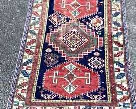 TOSH353 Handwoven Rug #5 Possibly antique and from Caucasus. Rug is approximately 57" long x 42" wide. There are several places where the thread is worn and a few spots where the fringe is missing.