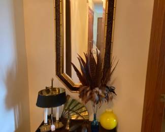 Hall mirror above small Asian chest.