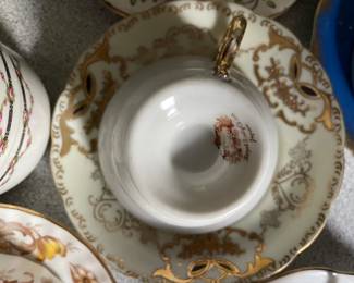 Bottom side of gold and white decorated teacup and saucer 