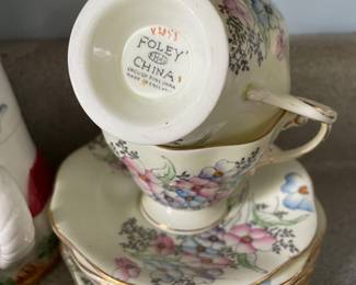 Bottom side of white, multicolored floral tea cups and matching saucers with gold detail 
