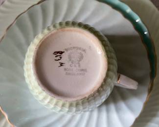 Bottom side of light green textured tea cup and saucers with gold detail