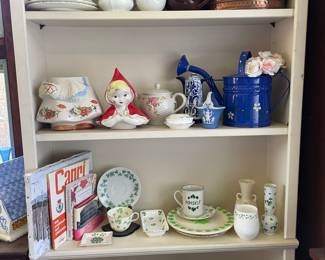 Picture of one entire shelf in sunroom, contains vintage cookie jar, teapot sets, Irish dishes, decorative plates