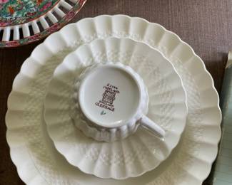 Bottom side of woven, scalloped 3D white ceramic plates and citrus design teacup 