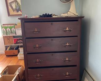 Dark wooden dresser with decorative brass handles in upstairs bedroom 