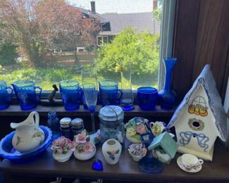 Top shelf/windowsill of blue glassware, delicate ceramics in sunroom 
