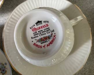 Bottom side of white textured tea cup and saucer with gold detail 