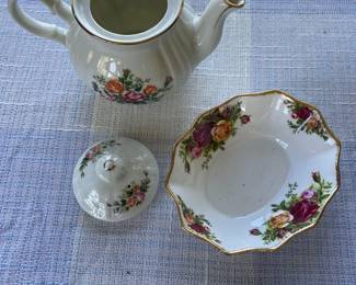 Small white, floral teapot and saucer with gold details, separated
