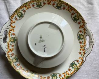 Bottom side of intricate multicolored festive ceramic dish set with gold detail 