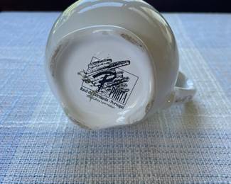 Bottom side of dainty white scallop edge gravy boat with ribbon, blue floral details