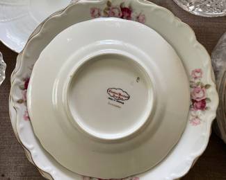 Bottom side of white scalloped light pink, neutral floral patterned ceramic dish 