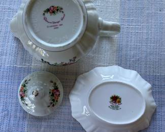 Bottom side of Small white, floral teapot and saucer with gold details