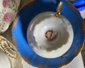 Bottom side of blue and gold ceramic teacup and saucer 