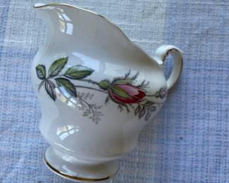 Small white, floral gravy boat with gold details