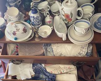 Assorted ceramic dishes and fabrics in den 