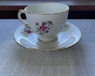 Small white, floral saucer and cup with gold details 