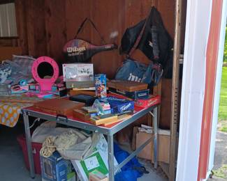 Drone, games, cribbage, beauty parlor, tennis racket and bag, golf bags.