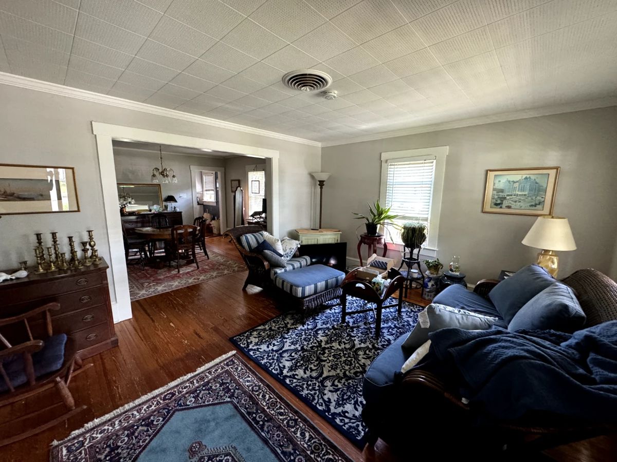 Living room - wicker couch and ottoman set, oriental rugs, lamps, dresser, mirrors