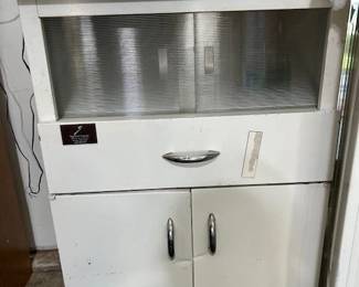 Dental cabinet. Top folds out. Glass doors slide. 