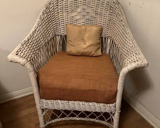 Here is a close-up of one of the wicker chairs, with a thick cushion on it.