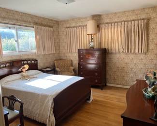 This is a slightly different photo of the bedroom furniture: bed, two dressers, chairs, and the doll on the bed.