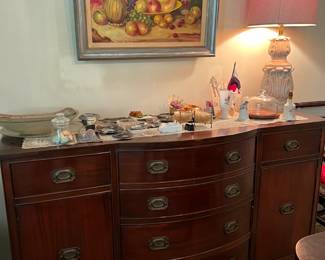 This is not a dresser, but a buffet table.  You can really store a lot of dishes and serving pieces here.  And don't forget the bowl of fruit painting.