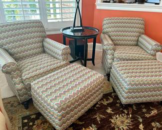 Pair of matching upholstered armchairs with ottomans