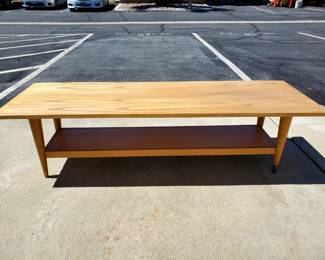 Selling this beautiful mid century modern coffee table that is in excellent condition. The table features a lower shelf and has brass on the base of its legs and is made of solid wood. The table measures 59" long, 19" wide, and is 15 1/2" tall.