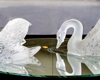 Lalique crystal swans centerpiece, "Miroir Cygnes", designed in 1943. Pair of frosted and molded crystal swans on an oval mirror base with beveled edges. Swans are marked under the tail.