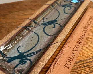 F11 - $25 signed pottery wall hanging. Measures 5" wide by 15" long.