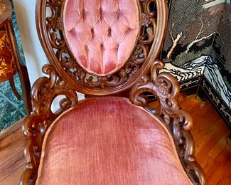 there are two of these chairs with pink velvet and lovely floral woodwork