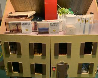 wooden doll house with many boxes of unopened furniture pieces