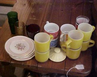 Vintage mugs plates, and glasses on a substantial end table.