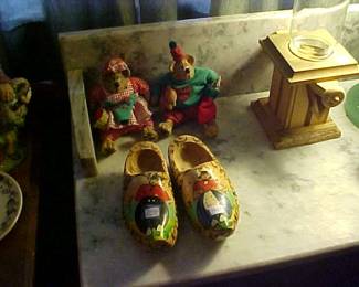 Bears, gumball machine and wooden shoes on an antique marble stand.