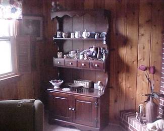 A vintage hutch full of figurines, Wedgwood, milk glass brass, and loads of other treasures.